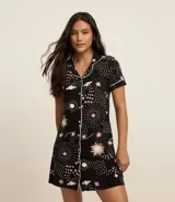 Camisón corto estilo americano confeccionado en viscosa certificada con estampado de estrellas y planetas. Tiene cuello solapa, abotonado delantero y bies contrastante.
