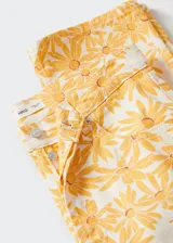 Pantalón de jean recto con estampado de flores amarillas.