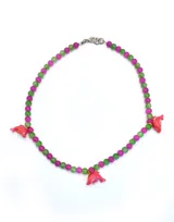 Collar hecho a mano con cuentas rosas y verdes, adornado con figuras de delfines en color rosado, con terminaciones en acero quirúrgico.