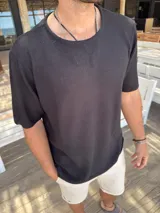 Buzo de hombre tejido de punto color negro, de manga corta y cuello redondo.