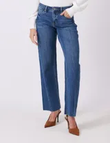 Jean de mezclilla azul, modelo wide leg con tiro medio/alto, cierre frontal y bolsillos. Presenta costura lateral asimétrica y bajo deshilachado.