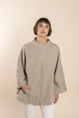 Capa marrón con bolsillos, mangas amplias y pinzas en la delantera. Terminaciones interiores envivadas. Confeccionada en lana fina sin teñir, diseñada exclusivamente por Don Baez.