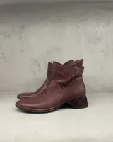 Bota corta de cuero color bordó, con taco bajo y costuras hechas a mano.