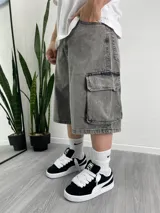 Bermuda gris de jean con bolsillos cargo laterales y corte holgado.