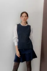 Mini falda azul marino de pana con volado en el ruedo, bolsillos delanteros y cierre metálico.