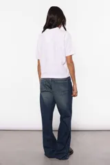 Remera blanca de jersey de algodón, corte boxy fit, con cuello redondo en rib al tono, mangas cortas y estampado de plastisol transparente centrado en la espalda.