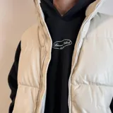 Chaleco puffer color crema, con cierre frontal y bolsillos laterales.