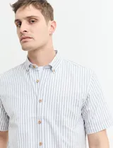 Camisa de manga corta a rayas verticales celestes y blancas, con cuello abotonado y corte clásico.