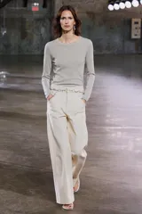 Sweater color beige de tejido de punto fino, con cuello redondo y mangas largas.