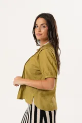 Blusa color verde oliva con cuello mao, mangas cortas abullonadas y cierre frontal con botones.