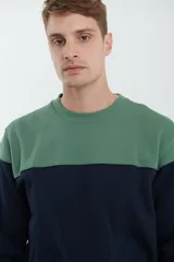 Sweater deportivo color beige con corte colorblock azul marino en el pecho y puños elastizados.