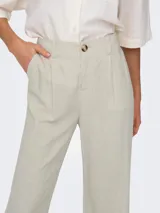 Pantalón de vestir color beige, de tiro medio y corte recto. Confeccionado en mezcla de lino y viscosa, con cierre de botón y cremallera, trabillas para cinturón y detalle de pinzas.
