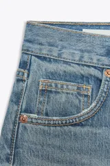 Pantalón de jean azul oscuro, de tiro alto, corte wide leg y largo hasta el tobillo.
