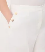 Bermuda de crepé color rojo, con pliegues frontales y botones decorativos en los bolsillos laterales.