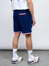 Bermuda deportiva azul con cintura elastizada ajustable con cordón, bolsillos laterales y escudo del Club Nacional de Football estampado en la pierna izquierda.