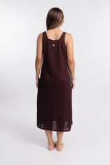 Vestido largo sin mangas, color crudo, con textura de tejido de punto abierto y escote cuadrado. Presenta paneles laterales en color marrón oscuro.