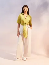 Camisa color verde lima con textura arrugada, corte holgado, mangas cortas y lazo para atar en la parte delantera.