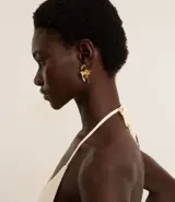 Par de caravanas doradas con forma de media flor esmaltada. Cierre con tornillo. Fabricadas con metal reciclado.