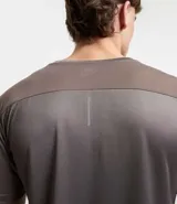 Remera deportiva blanca de poliéster, con cuello redondo, mangas cortas y recortes laterales.