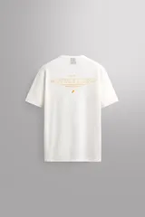 Camiseta relaxed fit blanca de lino y algodón, con cuello redondo y manga corta. Estampado frontal con la leyenda 'Athletic Run Club' en color amarillo.