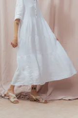 Vestido midi blanco de lino, con cuello camisero, mangas 3/4 y corte evasé.