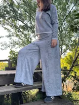 Conjunto de dos piezas en gris batik, compuesto por un buzo liviano de manga larga y un pantalón palazzo de tiro alto con corte evasé.