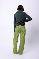 Campera corta de poliéster texturizado color verde oscuro, con cuello camisero, cierre frontal con botones a presión, bolsillos delanteros y forro interior. Incluye pins decorativos.