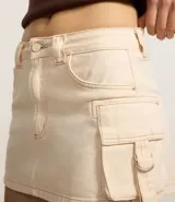 Minifalda color crema de sarga de algodón con bolsillos cargo laterales con hebillas metálicas ajustables.