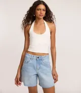 Bermuda de denim para mujer con cintura media y bajo deshilachado. Cuenta con trabillas en la cintura, cierre tradicional y bolsillos funcionales. Confeccionada en algodón con un toque de elastano.