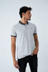 Remera tipo polo color ocre, de corte clásico, con cuello y mangas con terminaciones a contratono en azul marino y blanco.