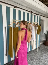 Vestido midi fucsia de lino, con cuello halter y corte recto.