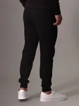 Pantalón de jogging negro Calvin Klein, de corte ajustado, con cintura elástica con cordones, puños acanalados, bolsillos laterales con cremallera y logo distintivo de la marca.