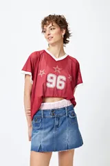 Minifalda de jean tiro bajo color negro con silueta evasé, dos tajos delanteros y ruedo desflecado.