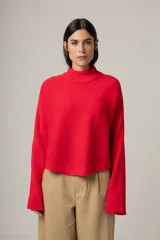 Sweater rojo de punto con cuello alto y mangas largas acampanadas.