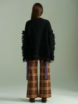 Sweater negro oversize de lana con cuello redondo, bordado central en forma de trenza, laterales con cuadrillé y mangas acampanadas desflecadas.