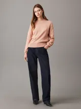 Sweater de punto color salmón, de corte relaxed, con cuello redondo y monograma bordado de Calvin Klein en el pecho.