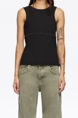 Camiseta sin mangas negra, de tejido acanalado, con escote redondo y una hilera de remaches metálicos plateados a la altura de la cintura.