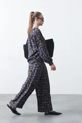 Pantalón de fit wide leg con estampado abstracto en tonos azul, marrón y beige. Presenta cintura elástica y caída fluida.