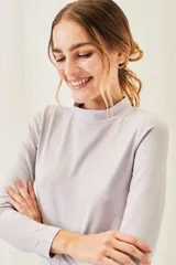 Polera negra de algodón y elastano, con cuello alto y mangas largas, corte ajustado al cuerpo.