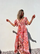 Vestido largo de color rosa con estampado floral, escote en V, mangas cortas con volados y corte imperio.