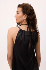 Minivestido negro de satén con escote halter y espalda descubierta.