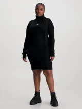 Vestido corto negro de punto acanalado, con cuello alto y mangas largas. Presenta logo de Calvin Klein bordado en el pecho.