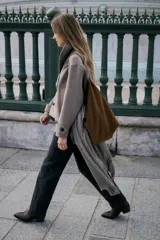 Bolso tipo shopper de gran tamaño, confeccionado en pana marrón con textura acanalada. Presenta un asa de hombro de cuero marrón y un detalle de tira ajustable con hebilla metálica en la parte frontal.