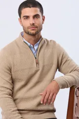 Buzo de punto color azul marino, con cuello alto y cierre frontal parcial con detalle de cuero. Presenta un diseño texturizado con franjas horizontales.