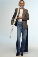 Pantalón de jean de tiro medio con cinco bolsillos, corte wide leg y detalle de tejido con lavado lateral combinado.