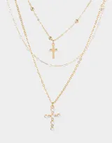 Collar corto de triple cadena dorada con dijes de cruces y perlas.