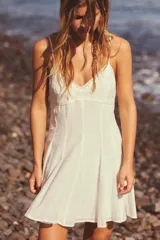 Vestido corto blanco de escote pico y tirantes finos ajustables. Detalle de bordados a tono. Forro interior. Cierre lateral con cremallera oculta en costura.