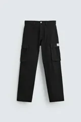 Pantalón cargo negro de corte relaxed fit, confeccionado en tejido de algodón con elasticidad. Cuenta con bolsillos frontales, traseros de vivo y bolsillos plastrón con solapa en las perneras. Tiene efecto lavado y cierre frontal con cremallera y botón.