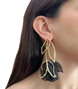 Aros colgantes con forma de rosa invertida, hechos en metal dorado con pétalos de tela negra.