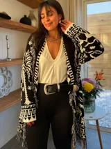 Sacón con estampado selvático en blanco y negro, tejido grueso tipo mohair y flecos artesanales. Incluye cinturón para ajustar la silueta.